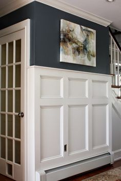 an entryway with white doors and blue walls in a house that has stairs leading up to the second floor