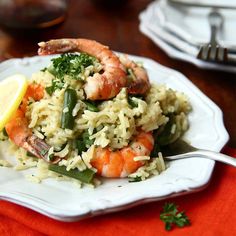 shrimp and rice with lemon wedges on a plate