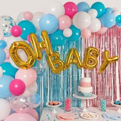 a baby shower with balloons, cake and streamers