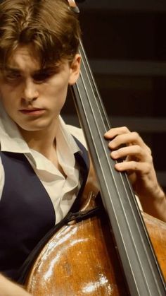 a young man is playing the cello