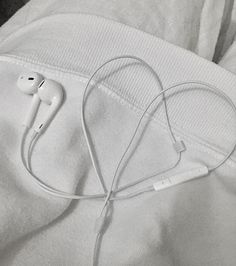 an earbud laying on top of a pair of white headphones in someone's pants