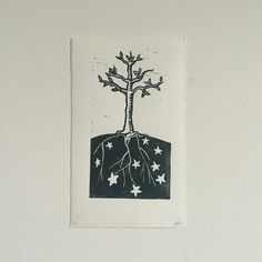 a black and white drawing of a tree with stars on it's roots in the ground