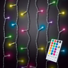 a remote control sitting on top of a string of christmas lights with multicolored lights behind it