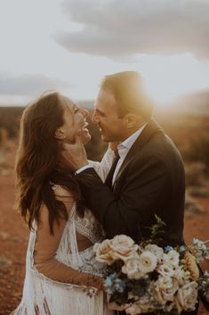 a bride and groom share a tender moment in the desert during their elopement