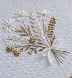 some white and gold flowers are on a piece of fabric