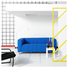 a blue couch sitting in the middle of a living room next to a yellow ladder