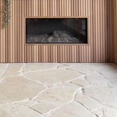 an empty room with a fireplace in the center and wood paneling on the wall