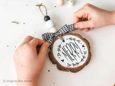 someone is decorating a wood slice with the word mom on it