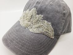 This is a new product from Handmade MKE! This is a distressed gray one size fits all baseball cap with a hole for your ponytail in the back, it is also adjustable. On the front of the hat is large rhinestone beaded applique in a beautiful art deco design. This is very comfortable, and great to throw on with a plain white T-shirt! Like our Facebook Page and get 10% off when you message me before checkout! Everything made by handmade MKE is one of a kind and unique, however, if you would like a di Embellished Adjustable Hat With Curved Brim, Adjustable Rhinestone Baseball Cap For Party, Adjustable Rhinestone Cap, Trendy Snapback Baseball Cap With Rhinestones, Trendy Rhinestone Baseball Cap, Trendy Rhinestone Snapback Baseball Cap, Rhinestone Baseball Cap One Size, Competition Bows, Dance Bows