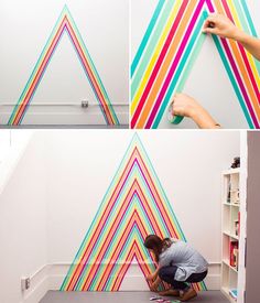 the man is painting on the wall with multicolored stripes and he is doing something