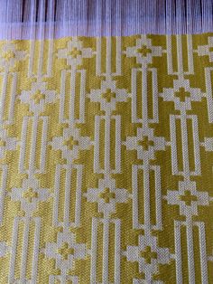 a close up view of a yellow and white pattern on a piece of fabric that has been woven