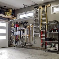 a garage filled with lots of different types of tools and equipment on the wall next to a ladder