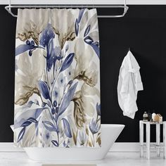 a shower curtain with blue flowers on it next to a white bath tub and towel rack