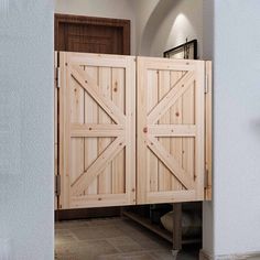 two wooden doors are open in the entry way to a house with tile flooring