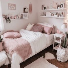 a bedroom with pink and white decor on the walls, bedding, rugs and shelves