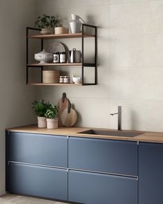 a kitchen with blue cabinets and shelves above the sink