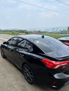 two cars are parked next to each other on the side of the road with power lines in the background