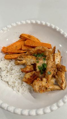 a white plate topped with chicken, rice and sweet potato wedges