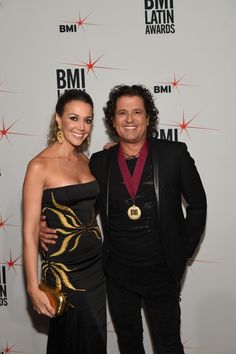 a man and woman standing next to each other on the red carpet at an event