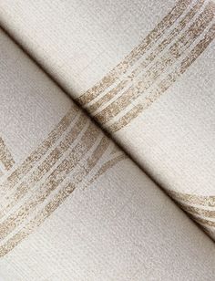 a close up view of a white and brown blanket with lines on it's edges