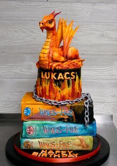 there is a cake made to look like a dragon on top of books with chains around it