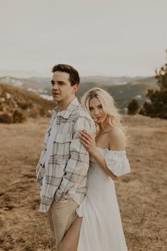 a man and woman standing in the middle of a field