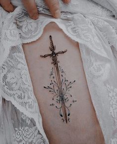 a cross tattoo on the back of a woman's stomach