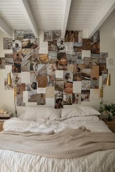 a bed with lots of pictures on the wall above it and a white comforter