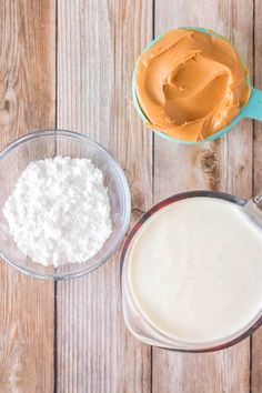 the ingredients to make peanut butter are in glass bowls on a wooden table with spoons