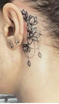 a woman's behind the ear has a flower tattoo on it