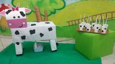 there is a cow made out of paper cups and straws in front of it