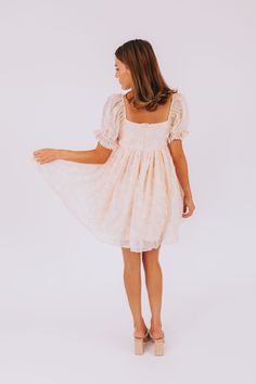 Light up with joy in the Sunlit Smile Dress! This playful mini dress features a sheer overlay and fully lined body in a lovely light peach color. The cinched waist and elastic sleeves add a touch of comfort and style, while the square neckline and sheer puff sleeves make it effortlessly chic. Details Light Peach dress with sheer overlay Fully lined Cinched waist Elastic in top and bottom of sleeves Short, sheer puff sleeves Mini length Square neckline Invisible zipper in back Sizing Approximate Sheer Puff Sleeve Mini Dress For Summer, Cream Mini Dress With Smocked Bodice For Spring, Feminine Peach Mini Dress For Brunch, Spring Sheer Square Neck Dresses, Peach Square Neck Summer Dress, Apricot Mini Dress For Day Out, Feminine Peach Mini Dress For Garden Party, Apricot Mini Dress For Brunch, Feminine Knee-length Puff Sleeve Dress With Smocked Bodice