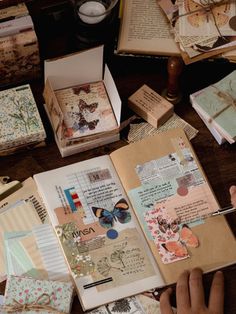 an open book sitting on top of a wooden table covered in lots of different types of papers