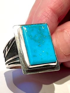 "This modern large Natural Intense Blue Battle Mountain Blue Gem Turquoise ring was fabricated in my studio using .999 Fine Silver & Sterling Silver.   This gorgeous all natural rare intense electric blue gem grade Battle Mountain Turquoise cabochon with it's unique natural matrix is amazing.   The cabochon is set with a 1/8\" tall .999 Fine Silver bezel.  The heavy cast sterling silver ring band is adorned with a lightning pattern. The band is soldered on a 24 gauge sterling silver back plate.  The Ring is approximately 24.7 mm ( nearly 1\" ) long x  18.4 mm ( nearly 3/4\" )  wide and weighs 15.4 grams. The cabochon is beautiful and measures approximately 20.6 mm x 14.2 mm. The ring is a Size 11. I am not able to resize it. The Blue Gem Turquoise Mine was located in the Copper Basin area Mens Turquoise Rings, Lightning Pattern, Bisbee Turquoise, Silversmith Jewellery, Sterling Silver Rings Bands, Blue Gems, Aqua Color, Blue Turquoise, Turquoise Jewelry