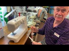 an old man sitting in front of a sewing machine