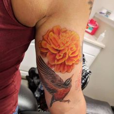 a woman with a tattoo on her arm has a bird and flower in the center