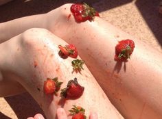 two people with their legs covered in strawberries