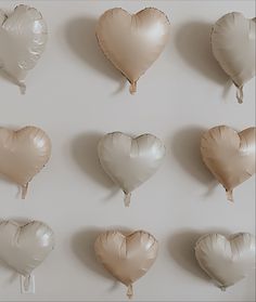 several heart shaped balloons are hanging on the wall in different shapes and sizes, along with one another