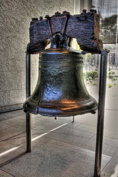 a large metal bell sitting on top of a sidewalk