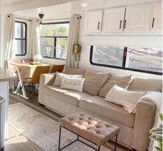 a living room filled with furniture next to a kitchen