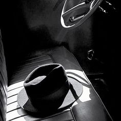 a black and white photo of a hat on the seat of a car