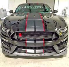 the front end of a black mustang in a garage