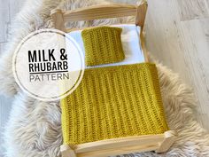 a wooden rocking chair with a knitted seat cover on it and the words milk & rhubarb written in white