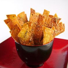 a black cup filled with cheetos on top of a red plate