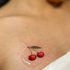 two cherries on the side of a woman's breast