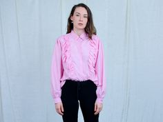 "AUNT GERTRUDE PRESENTS - vintage long sleeve pink shirt - frill at the front - materials: polyester CONDITION (1-10 ❶❷❸❹❺❻❼❽❾ Great condition SIZE/MEASUREMENTS size from label: 44 best fits: XL/XXL shoulder to shoulder: 16 inches (40 cm) bust: 44 inches (112 cm) length: 27 inches (68 cm) sleeve length from armpit: 18,5 inches (47 cm) The model is 5'9\" (174 cm), measures 35-27-38 (90-69-96 cm) and wears size M" Feminine Long Sleeve Ruffled Tops, Feminine Long Sleeve Ruffle Tops, Spring Retro Blouse With Ruffles, Pink Fitted Top With Ruffled Collar, Fitted Pink Blouse With Ruffled Collar, Pink Long Sleeve Blouse For Daywear, Elegant Pink Ruffled Shirt, Pink Long Sleeve Retro Top, Pink Ruffled Collar Blouse For Fall