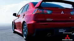 the rear end of a red car on a road