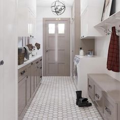 a long hallway with white cabinets and tile flooring