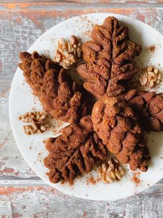 a white plate topped with cookies covered in nuts