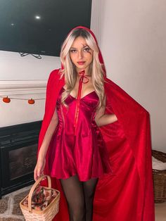 a woman dressed as a red riding hood and cape holding a basket in her hand